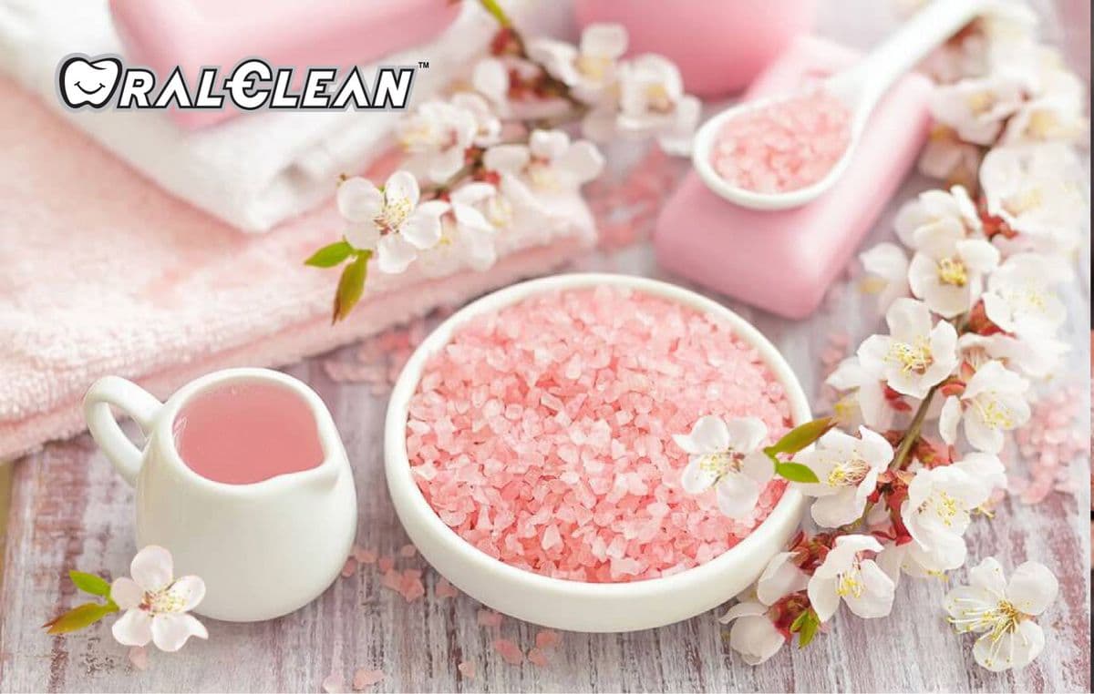 Muối hồng Himalaya trong chén, bên cạnh hoa trắng